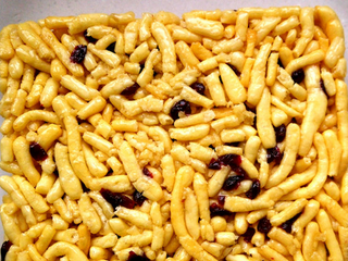 6、自制蔓越莓沙琪玛,彻底晾凉后，倒扣在油纸上，切块就可以啦