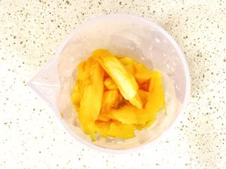 6、颗粒感十足的芒果芭蕉壁挂奶昔,芒果果肉加入搅拌机桶中