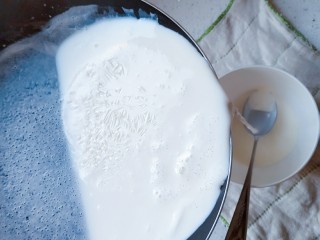 10、午后时光_红枣双皮奶,将平底锅里的牛奶倒回碗里，慢慢倒不要急，锅的角度不要倾斜的太狠