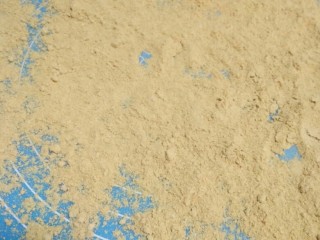 6、驴打滚,将黄豆粉均匀的撒在案板上。