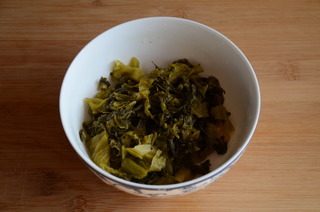 7、酸菜鱼,酸菜在开水中汆烫下,捞出冲洗后沥干水分,切成细丝