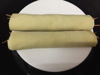 8、健康素食之豆腐皮卷素菜,卷好后放到盘里,入锅大火蒸8分钟