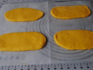 8、胡萝卜口袋面包,面团擀成大约20CM长度的长舌状，盖住保鲜膜，醒10分钟