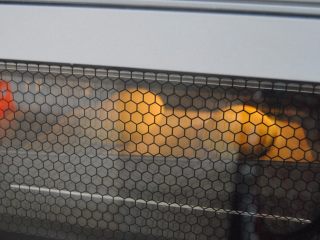 9、胡萝卜口袋面包,把2个面胚连同油纸一起放入烤盘，中下层烤5分钟，2-3分钟左右就会看到面包鼓起来