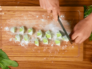 14、豌豆苗树叶饺子,把美食吃出艺术感,面板上撒少许面粉,将面团搓成长条,滚刀切剂子