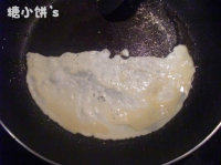 4、轻松熊便当,平底锅刷一层底油烧热后倒上蛋液