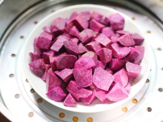 2、香甜软糯的奶香紫薯芝麻方饼,锅中蒸熟。