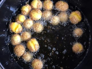 13、南瓜开口小麻薯,锅中放适量的食用油烧至五成热,把南瓜球放进去炸(不要大火油炸哦)之后会不断听到“砰、砰、砰”的声响,开口了就捞出控油即可