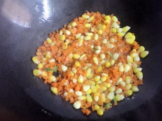 7、百变鸡蛋+蛋包饭,倒入胡萝卜丁翻炒至熟，再倒入焯熟的玉米粒翻炒几下。
