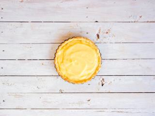 16、柠檬塔,将烤制半熟的塔皮取出,铺入柠檬酱,尽量抹平整