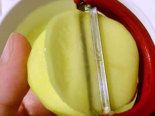 3、平底锅版健康无油香脆薯片,用削皮刀将土豆削成薄片，尽量根据土豆外形削成圆片或者椭圆形，不要削细长的片状，不利于后面烘烤