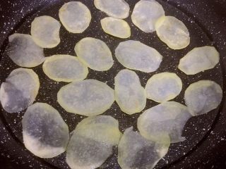 7、平底锅版健康无油香脆薯片,平底锅不粘锅开小火，将土豆片一片一片码放在锅内，制作过程，全程开小火