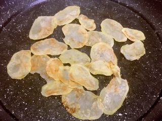 10、平底锅版健康无油香脆薯片,两面全部呈金黄色后，再用筷子将土豆片聚拢在锅中间，继续烘三十秒左右，期间用筷子扒拉扒拉，注意不要烘焦了