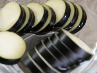 2、这样做的茄盒不用炸,煎烧茄盒少油健康又入,将茄子打湿,捞出备用