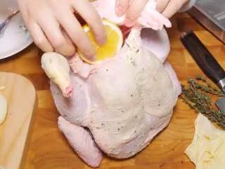 5、百里香烤鸡,把鸡提起来，把柠檬、百里香、蒜头放进去，最后塞进剩下的柠檬