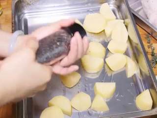 8、百里香烤鸡,倒入一大勺油，适量的盐、黑胡椒拌匀，把土豆推到烤盘四周