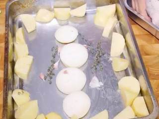 9、百里香烤鸡,把切好的洋葱片排在中间，把蒜头和百里香放边上