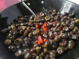 9、香辣螺蛳,翻炒个一分钟左右后，将尖辣椒、花椒、生姜、蒜一起倒入锅内，继续翻炒