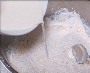 3、肉桂苹果派,放入盆中,倒入淡奶油和水,揉成面团