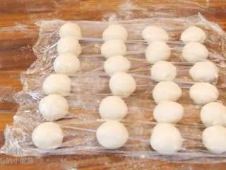 10、酥皮鲜肉月饼,取一个水油皮面团按扁，放入油酥包起来，搓圆，盖上保鲜膜醒面15分钟