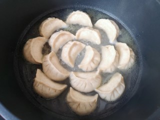 23、冰花锅贴,加入没过锅贴三分之一的水，盖上锅盖焖煮至水收干。