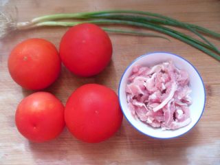 1、番茄肉丝浓汤,备好食材,瘦肉洗净切细条,盛入碗中,调入盐、鱼露、拌匀片刻,再加些淀粉、香油搅拌均匀腌制15分钟以上,小葱洗净切段