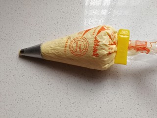 8、小熊柠檬蛋黄饼干,然后把拌好的蛋糊装入有圆形裱花嘴的裱花袋中，要预留一点蛋糕哦；