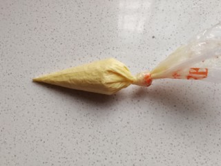 9、小熊柠檬蛋黄饼干,接着把预留的蛋糊装入另一个裱花袋，裱花袋剪一个小口；