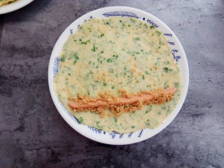 16、#咸味#芹菜鸡蛋火腿肉松饼,取一根火腿肠，撒上适量肉松，把饼卷起来