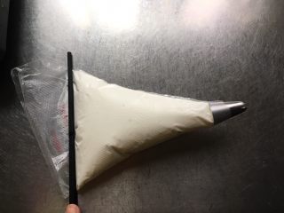 9、宝宝零食酸奶溶豆,提起裱花袋面糊不会流动，平放桌面，用筷子由裱花袋口平压将糊推至裱花嘴处，提起裱花袋收口，一手握紧，不要触碰裱花袋中间部分，以免手温导致消泡。