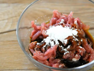 1、金针菇控们在哪里？赶快来围观,肉丝里倒入盐、老抽、淀粉、料酒拌匀，腌制10分钟。