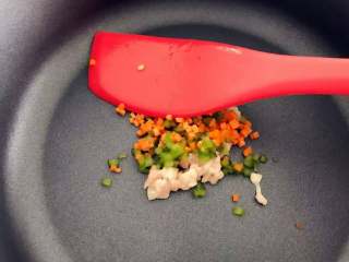 2、宝宝辅食：茄子圈蛋饼,热锅，放入鸡蛋液中的配菜（小芽加的是肉糜、青椒和胡萝卜），中火翻炒2-3分钟，七八成熟后盛出备用。