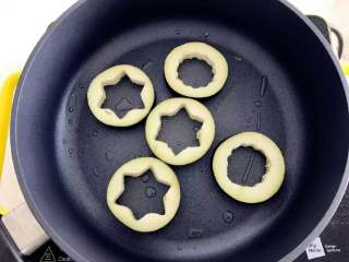 5、宝宝辅食：茄子圈蛋饼,热锅，倒入少许植物油，放入步骤1中处理好的茄子圈，中小火慢慢煎2-3分钟，可翻面。