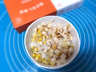 6、儿童雪人便当,把香肠和玉米粒加入香油和米饭搅拌均匀。