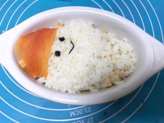 9、儿童雪人便当,继续加入些白米饭，用海苔装饰雪人眼睛和嘴巴。