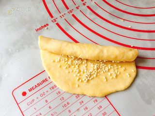 6、咸香芝麻饼,将饼皮由上往下卷起来，尽可能卷得紧凑一些。