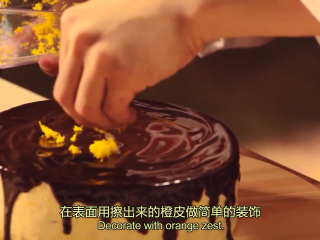 18、橙香米蛋糕,蛋糕从冰箱取出脱模,散热,淋上巧克力甘纳许,再用橙皮做简单装饰