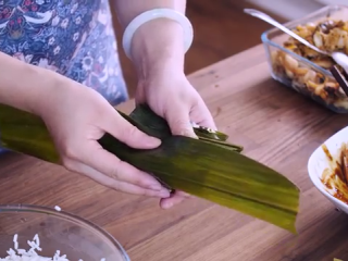 12、鲜肉粽子,两边往中间折，取另一片叶子，如图，毛面朝内，包好，两边往中间折，另一边亦如此