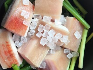 3、东坡肉,将肉块码在葱上，撒一把冰糖盖在肉上。