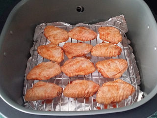 5、奥尔良烤鸡翅 ,将腌好的鸡翅正面朝上、放至空气炸锅的高架网上