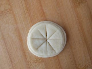 11、原味麦香小面包,制作太阳:另取剩下的面团,擀成薄片,在每篇中间刷油后,摞在一起,如图切开,边缘不要切断。