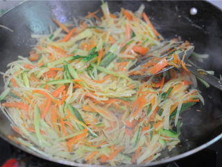 7、蒸饼卷菜,加入胡萝卜丝和黄瓜丝一起炒熟，加盐调味即可出锅备用