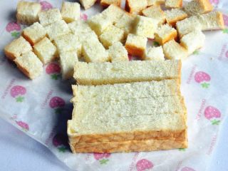 12、蔓越莓吐司布丁,将吐司切成小方块，有些人喜欢去掉边角，而我喜欢连边角一起烤，虽然上色会深一点，但我喜欢烤后香脆的口感。