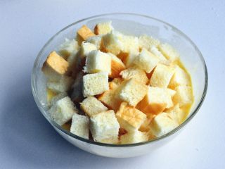 16、蔓越莓吐司布丁,将吐司块放入装蛋奶液的碗中