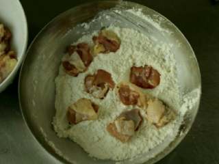 5、烤鸡米花,剩下的1/4汤匙盐放入面粉拌匀,夹几块肉丁放入面粉中