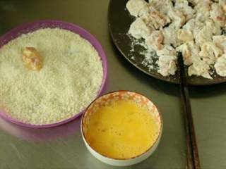 7、烤鸡米花,把裹上面粉的鸡肉丁在蛋液中粘蘸一下,之后放入面包糠中