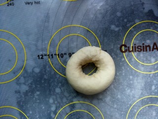 8、贝果三明治,然后将另一头与压扁的那一头链接在一起，捏紧收口，如图，做成甜甜圈的模样