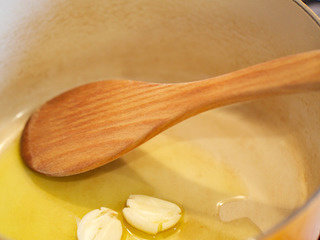 2、烩牛尾,预热橄榄油，煎香蒜瓣至焦糖色。烤箱预热180度