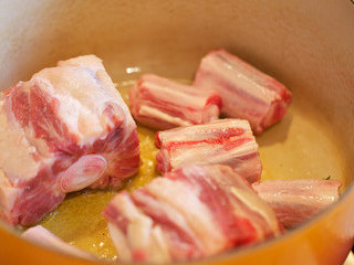 4、烩牛尾,当油温变细且有微烟时放入拭干的牛尾