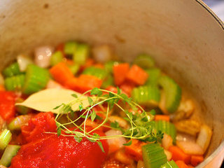 8、烩牛尾,放入蕃茄、香叶、百里香一同翻炒